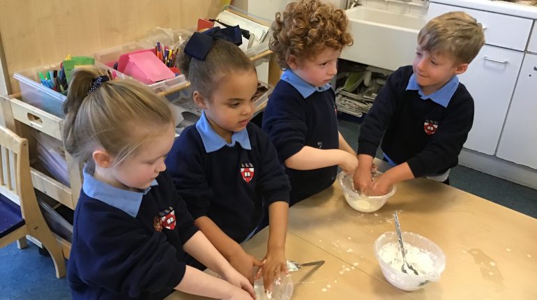 Four children at school mix dough in a bowl