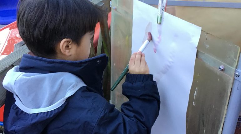 Child painting onto a piece of paper