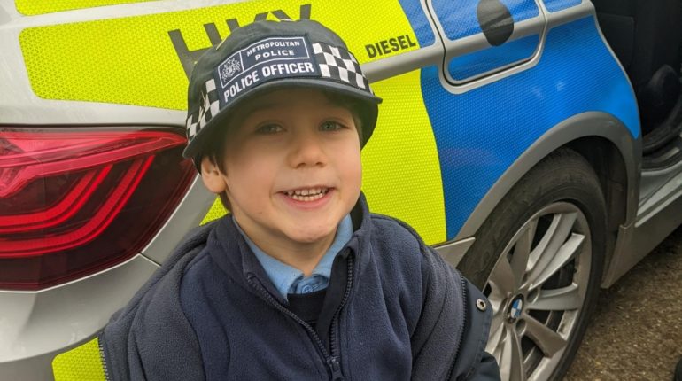 Child wearing a met police hat