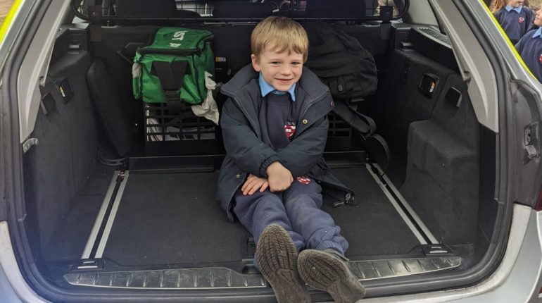 Child sat in the boot of a car