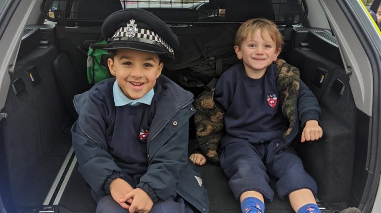 Children sat in the boot of a police car