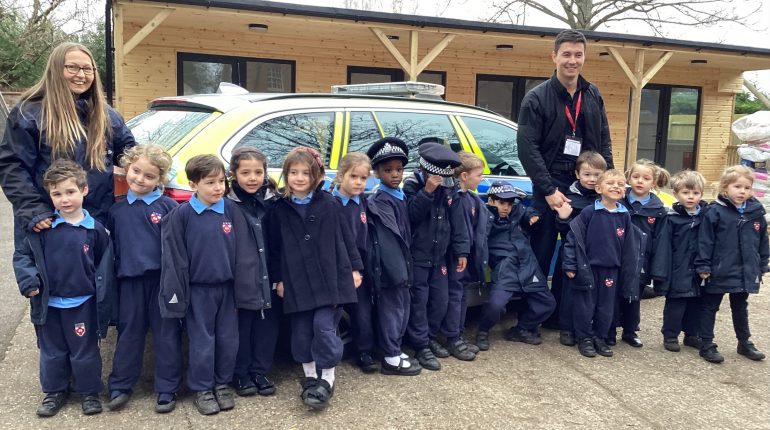 Children stood by the police car with the teachers