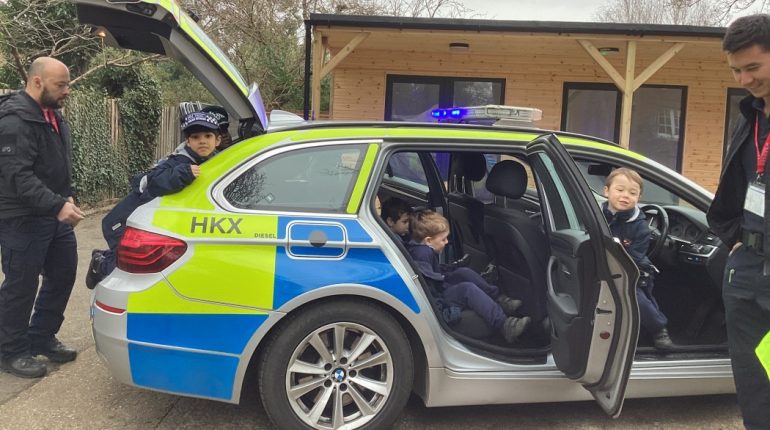 Children by the police car having fun