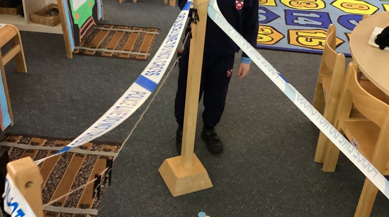 Child stood by a police line being made in the classroom