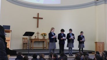 4 students reading at the front of the class