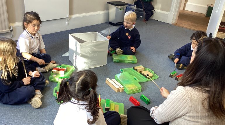 children learning to use xylophones