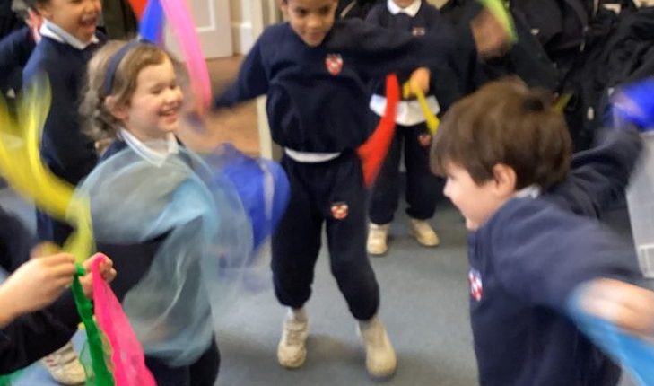 children dancing with fabric in their hands to the music