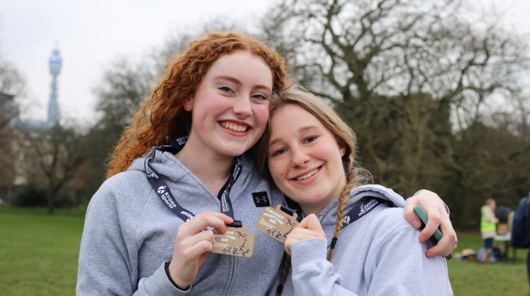 2 students holding medals up