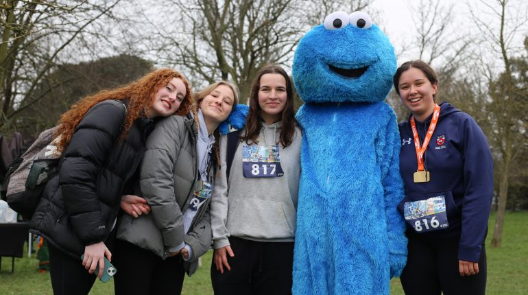 students after the race with a cookie monster mascot