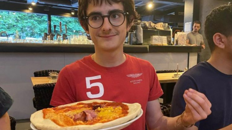 boy holding a pizza