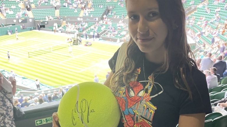 girl holding a signed ball
