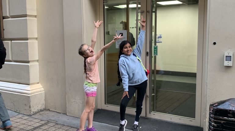 students pointing at a stage door