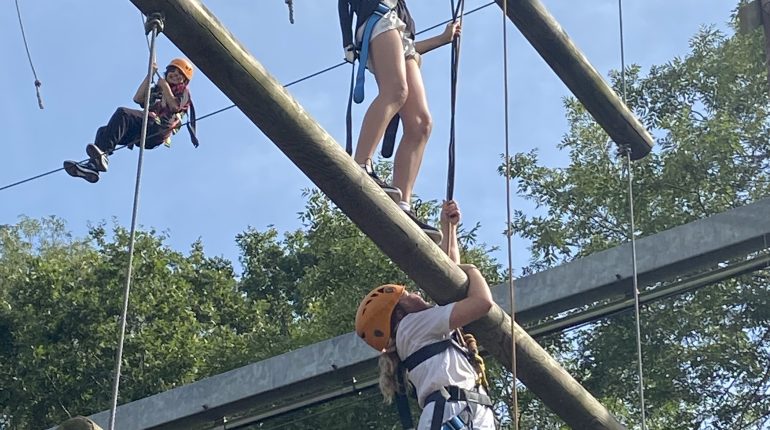 students climbing onto wooden platforms