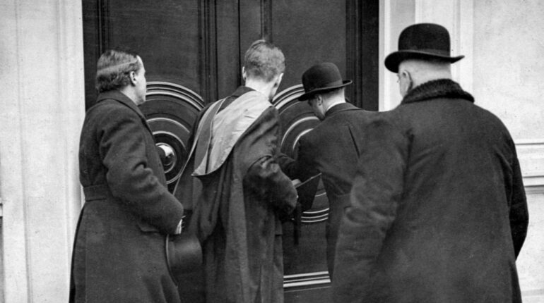 old photo of men opening a door